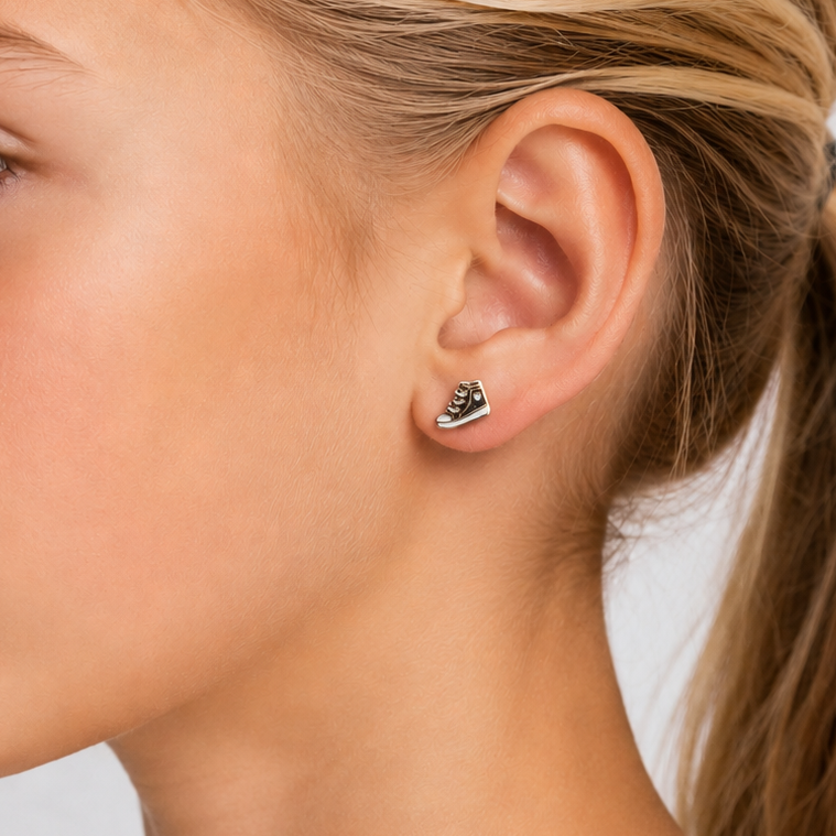 Close-up of a young girl wearing heart-shaped earrings with a plain background