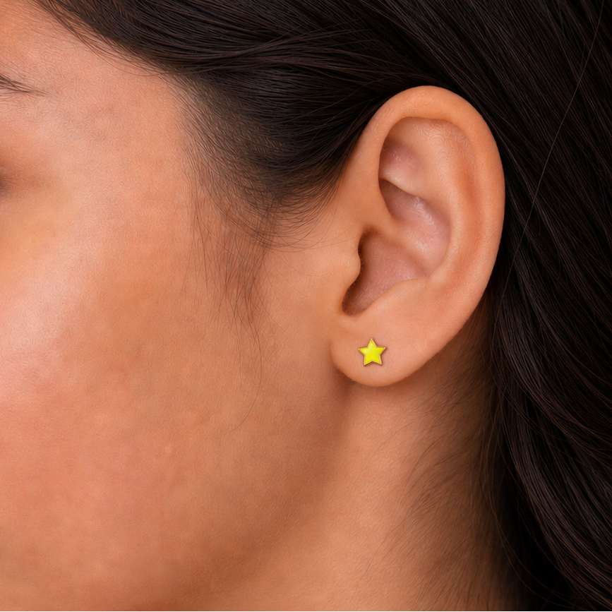 Close-up of a person wearing a yellow star-shaped earring on a neutral background