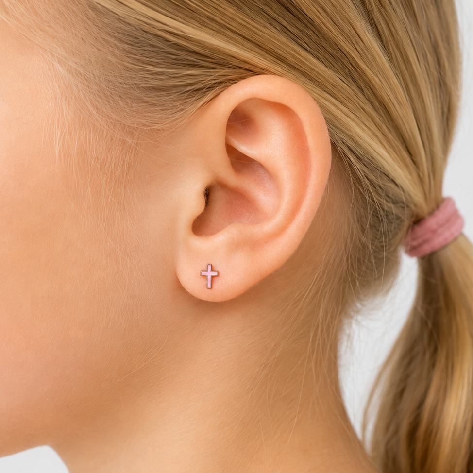 Close-up of a child's ear with a small earring, on a plain background
