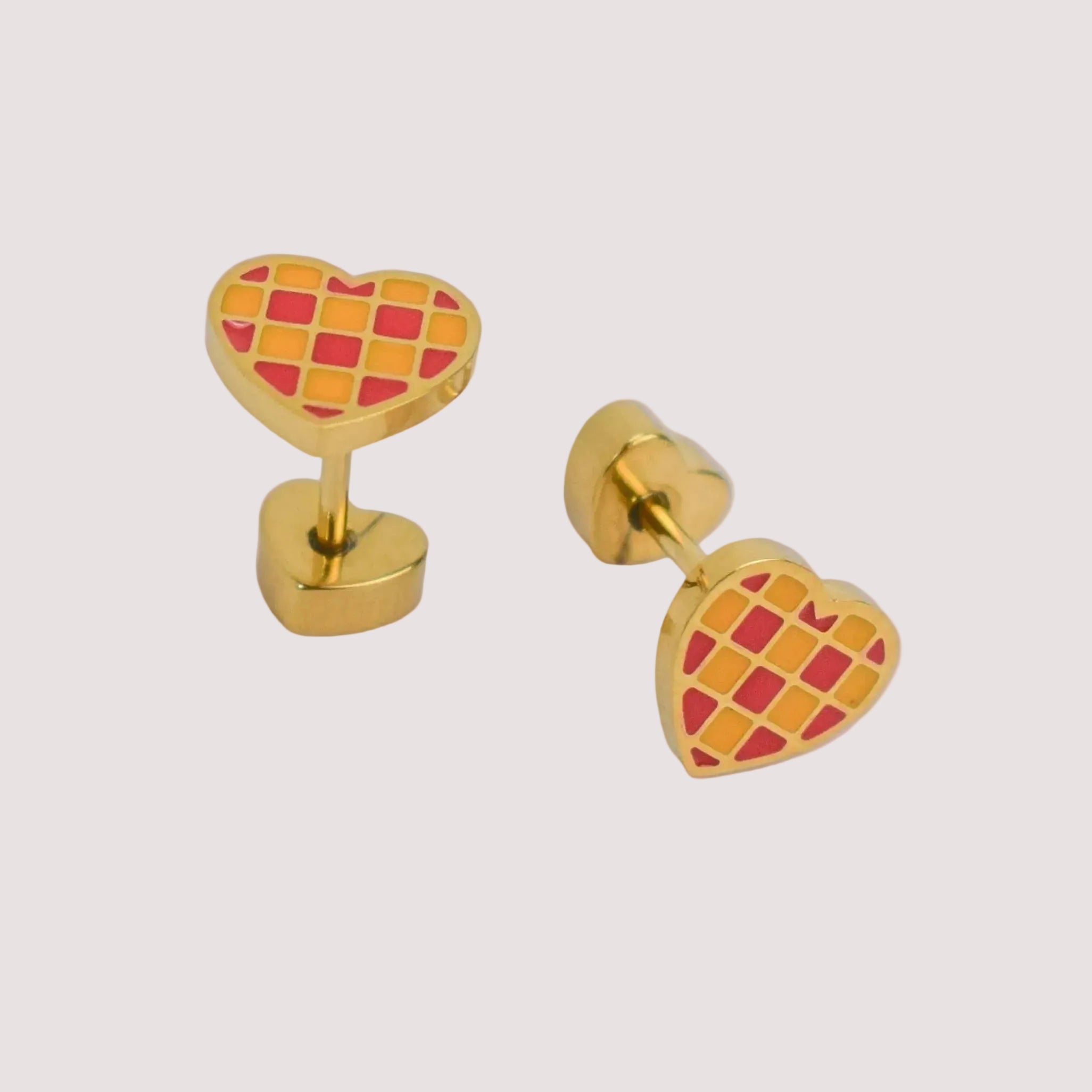 Heart-shaped earrings with red and yellow pattern on a light gray background
