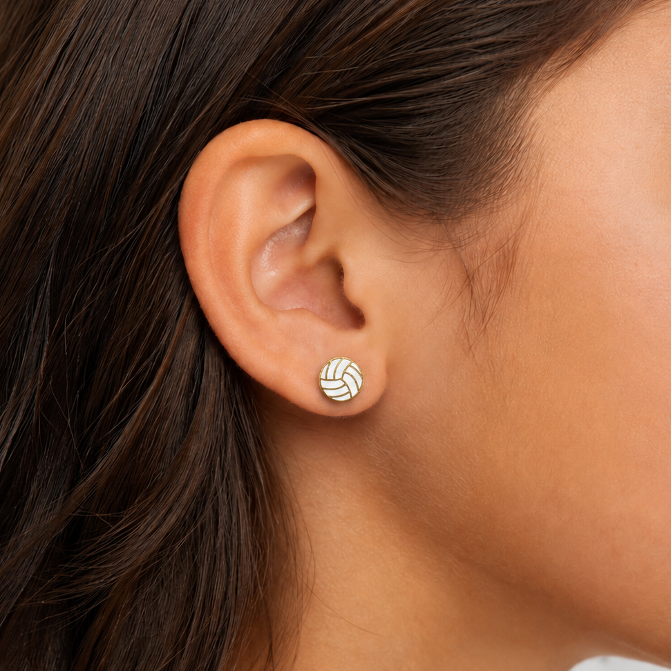 Close-up of a girl wearing a gold earring with a white volleyball.